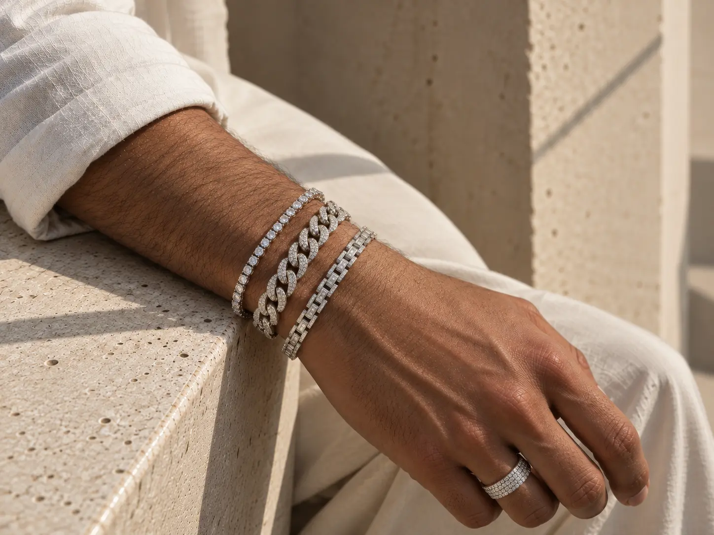 Men’s diamond pavé curb link bracelet and matching statement ring resting on rich dark chocolate-brown pleated silk.