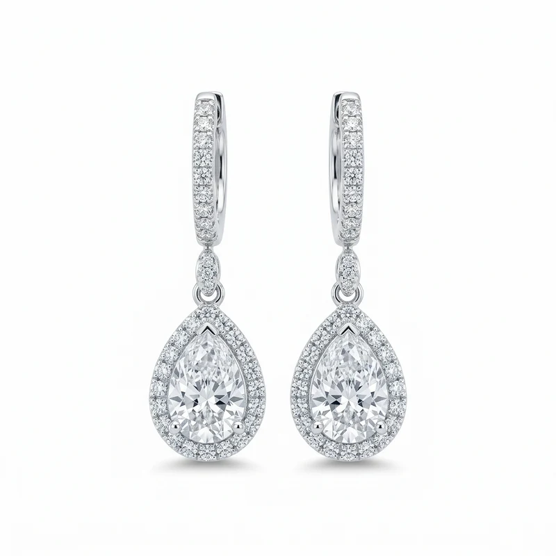 A pair of white-gold pear diamond halo drop earrings on pure white.